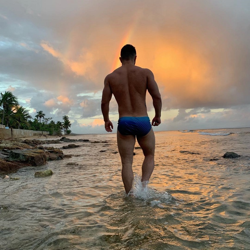 Bremen Menelli walking in shallow waters by the sea during a twilight looki...