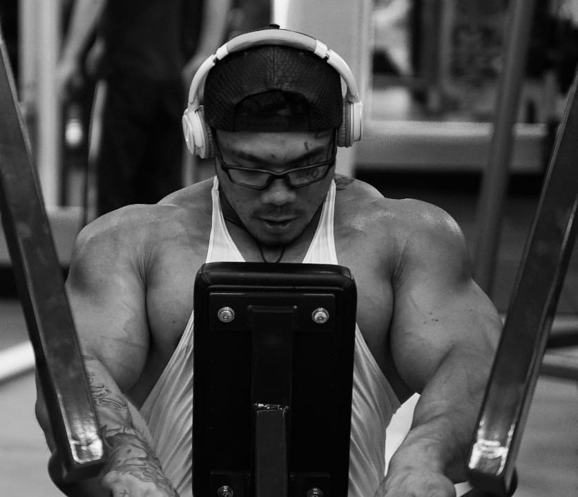 Caio Eiji Sirahata exercising his chest on a machine in a gym