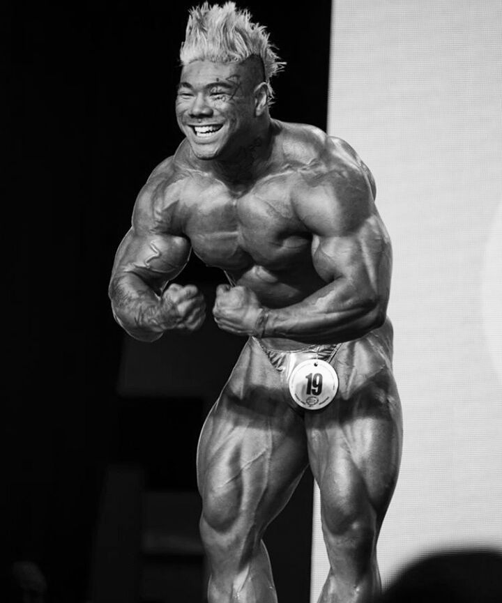 Caio Eiji Sirahata performing a most muscular pose on the bodybuilding stage