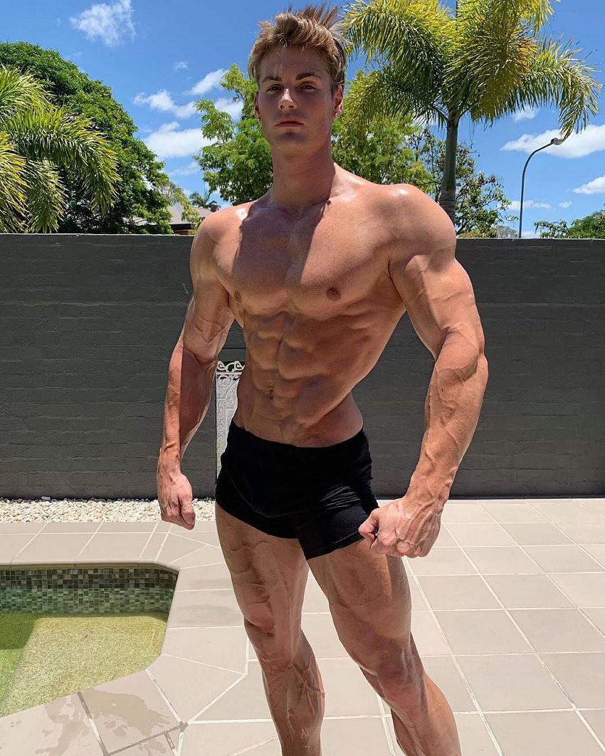 Carlton Loth posing shirtless in his backyard looking ripped and fit