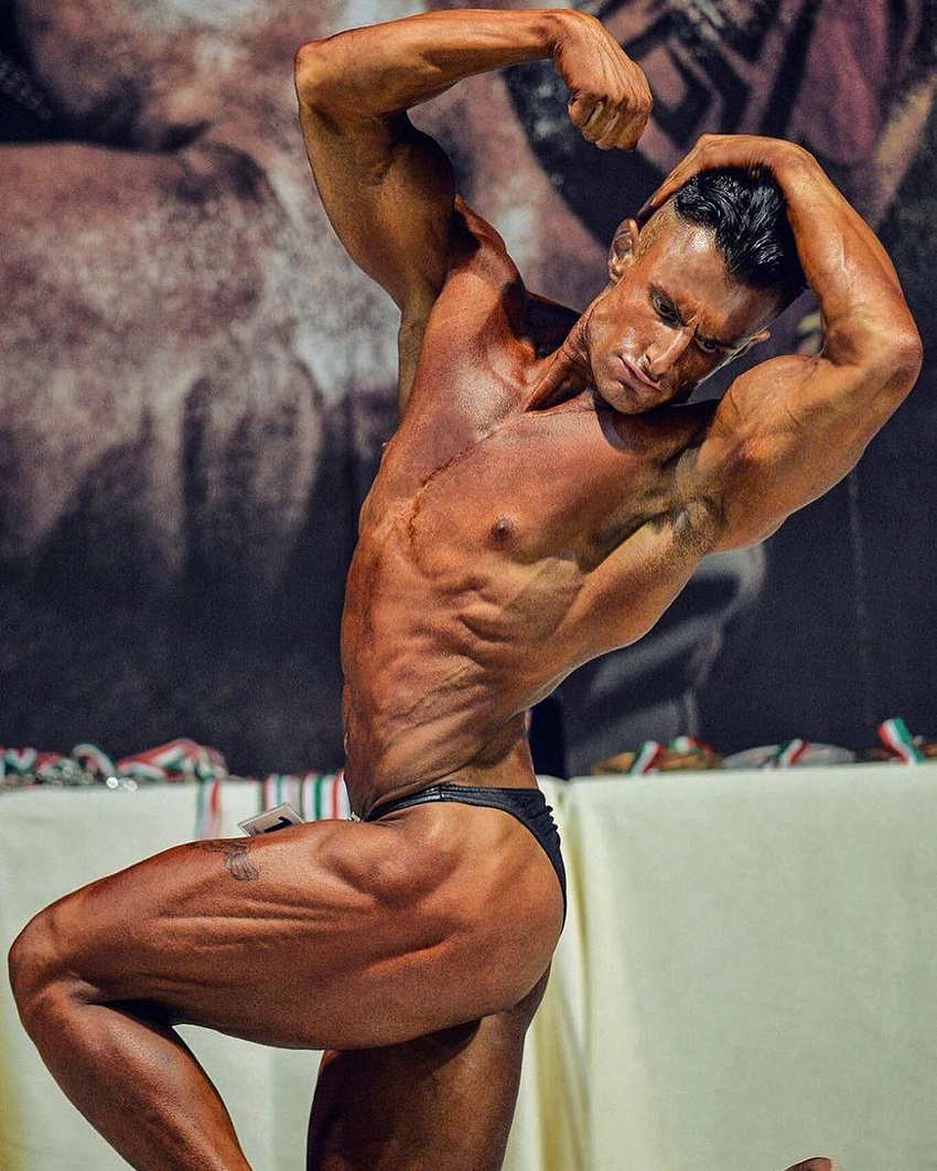 Francesco Della Vedova flexing his muscles on a bodybuilding stage