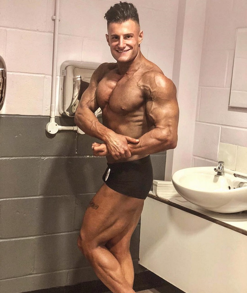 Francesco Della Vedova standing shirtless next to a sink flexing for the photo