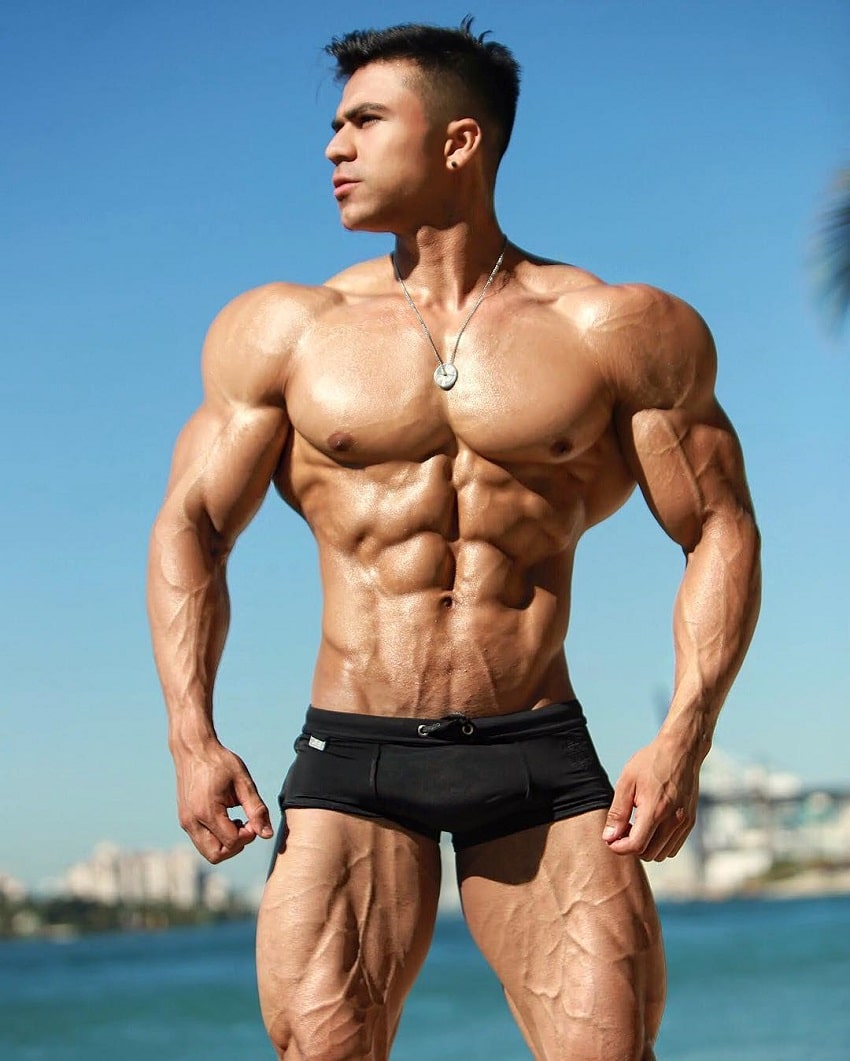 Ismael Martinez posing shirtless on the beach, looking ripped and vascular