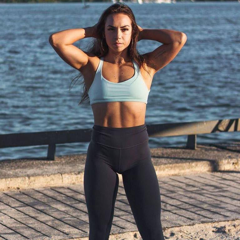 Kenzie Forbes posing on a pier showcasing her fit figure