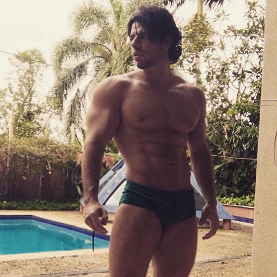 Lucas Giovani standing shirtless by the pool looking ripped and muscular