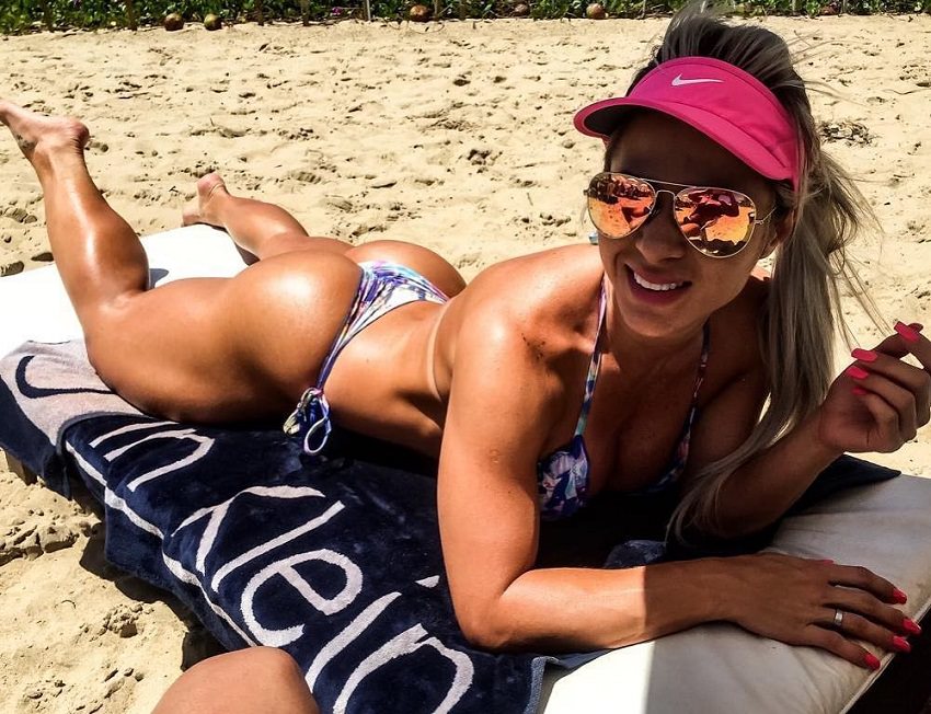 Mari Carvalho lying on a beach in a bikini and with sunglases, looking curvy and fit