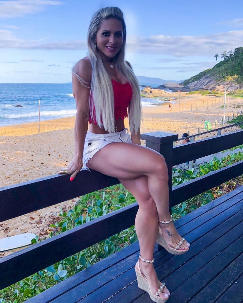 Mari Carvalho sitting on a porch smiling for the camera, looking fit and toned