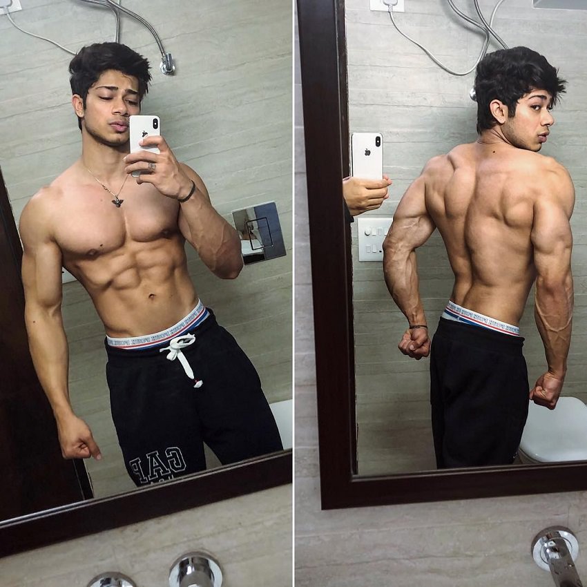 Vasu Mittal posing in front of a mirror showing off his ripped muscles