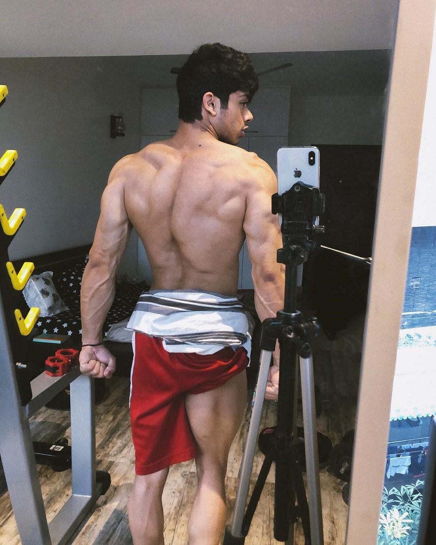 Vasu Mittal posing in front of a mirror showing off his aesthetic back