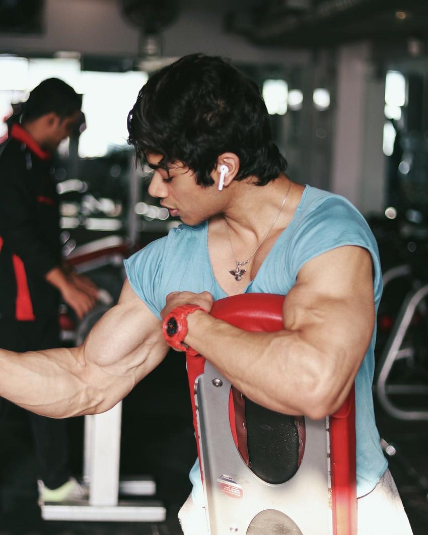 Vasu Mittal training his bulging biceps in the gym