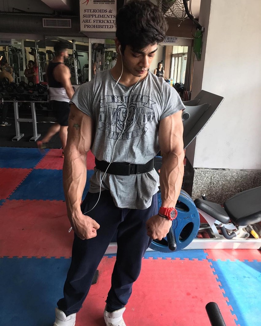 Vasu Mittal posing in a gym looking vascular and ripped