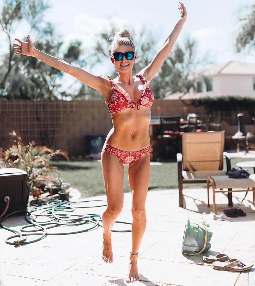 Alexa Jean in a bikini, with her arms wide and smiling at the camera, looking fit, lean, and happy