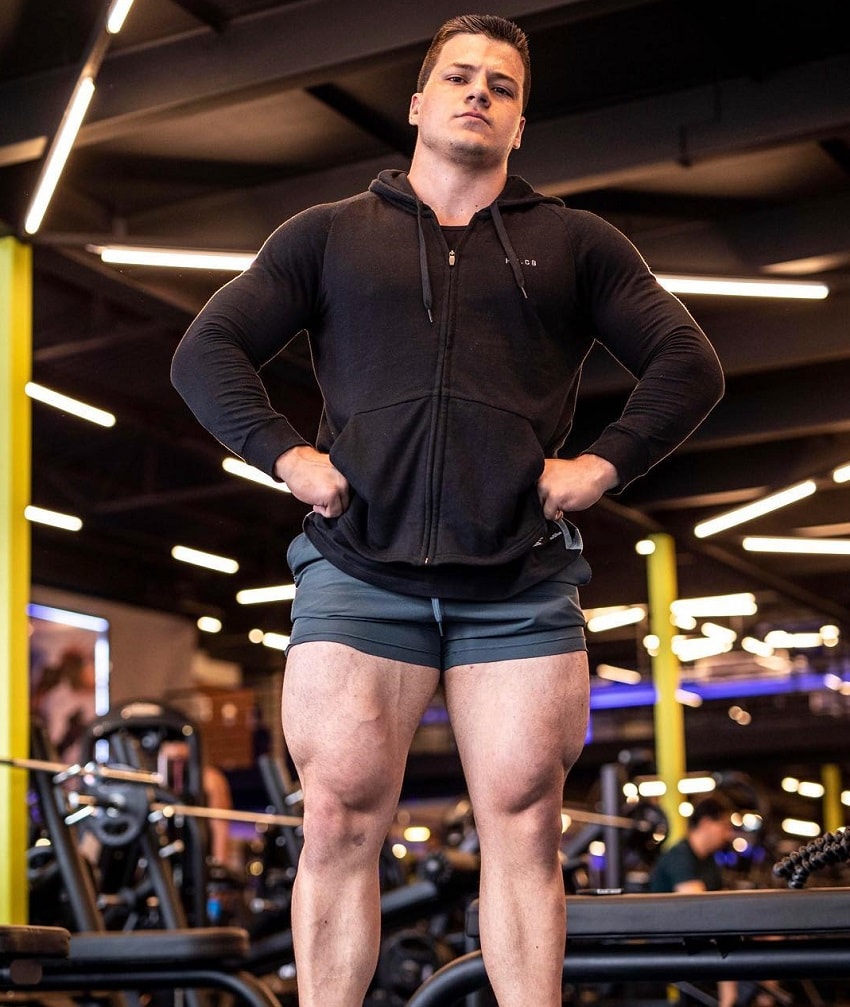 Caio Bottura posing in the gym showing off his huge legs