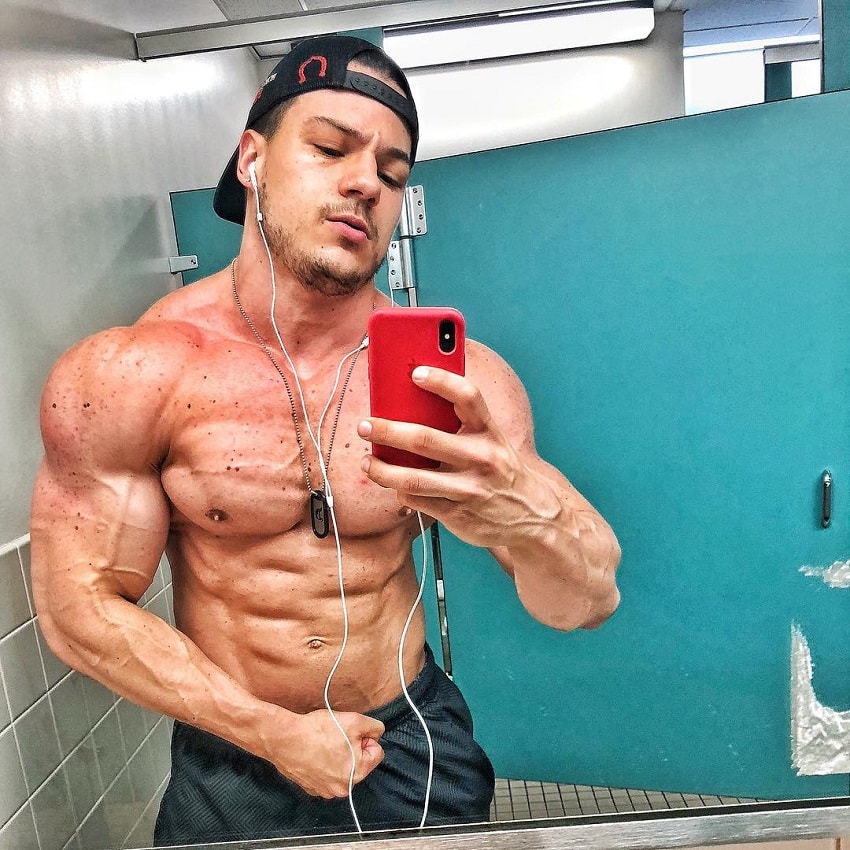 Caio Bottura taking a shirtless selfie looking ripped and vascular