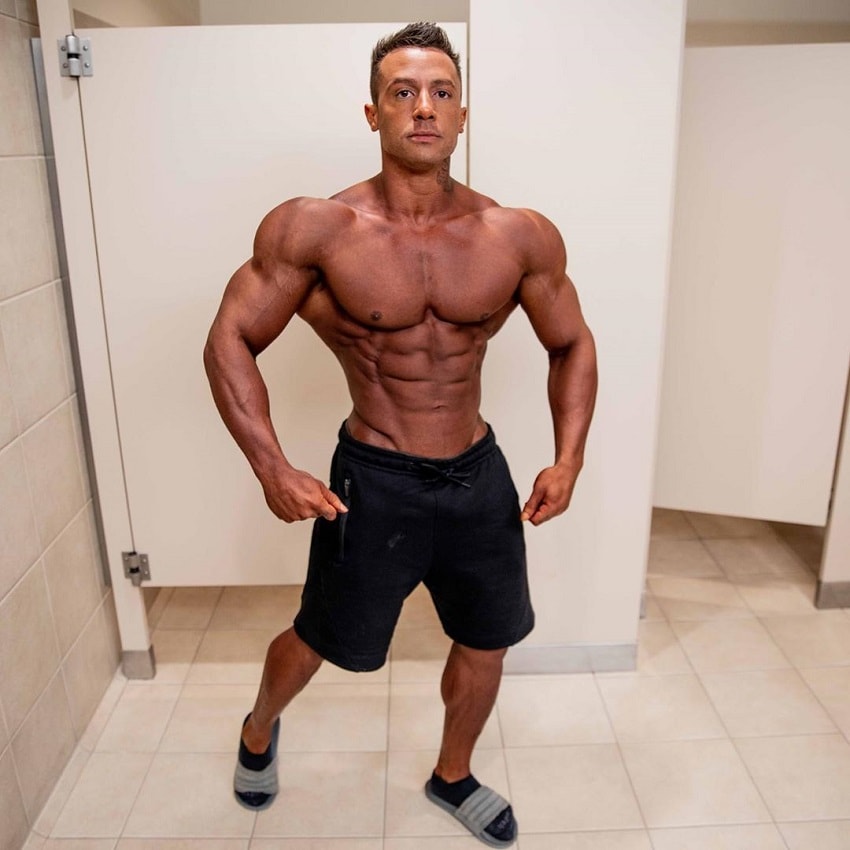 Diogo Montenegro posing shirtless in a gym locker room, looking tanned up and aesthetic