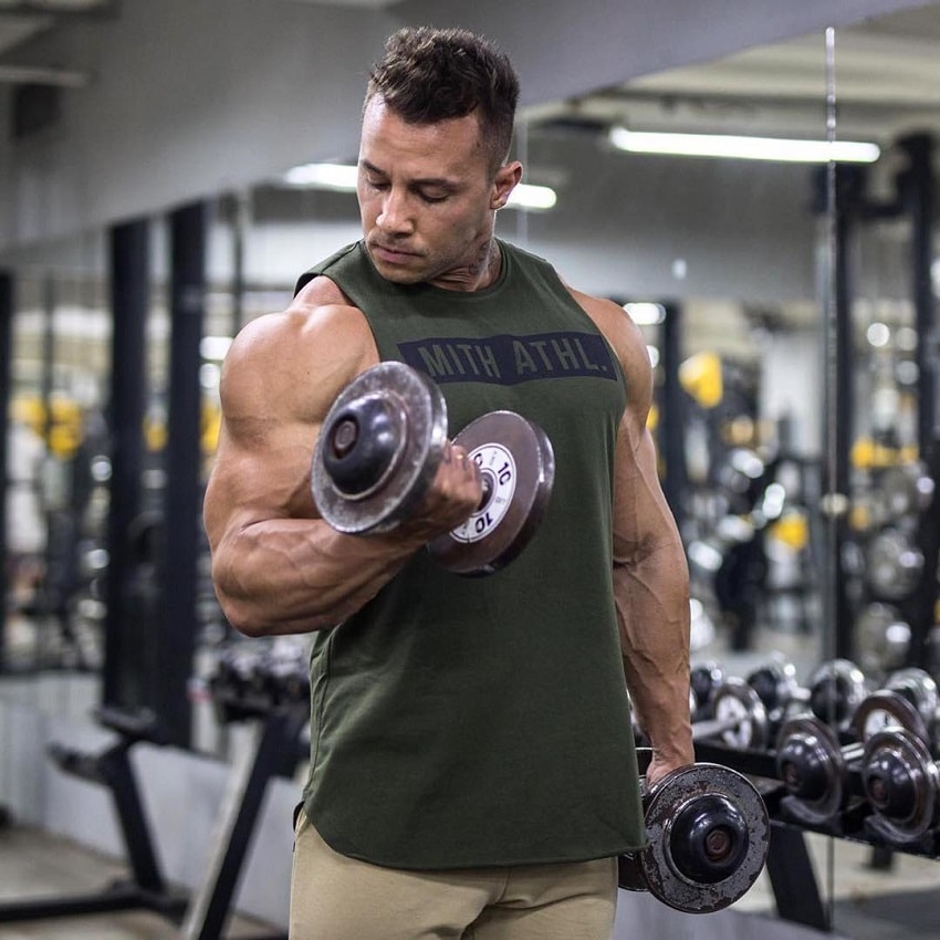 Diogo Montenegro doing standing biceps curls in the gym