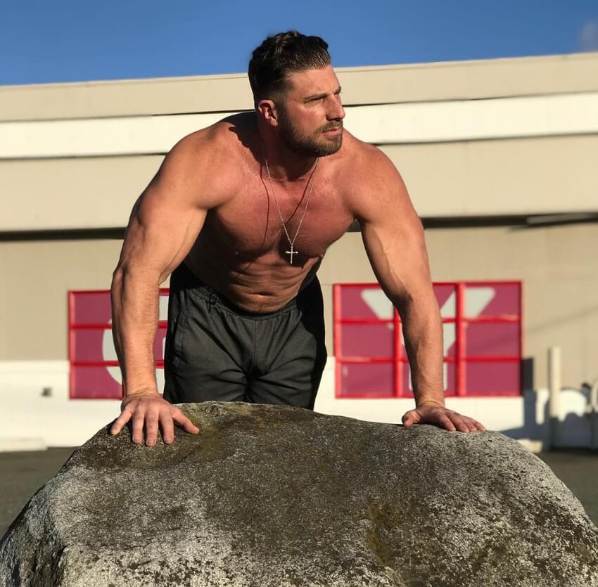 Gabe Moen leaning against the rock, looking strong and big