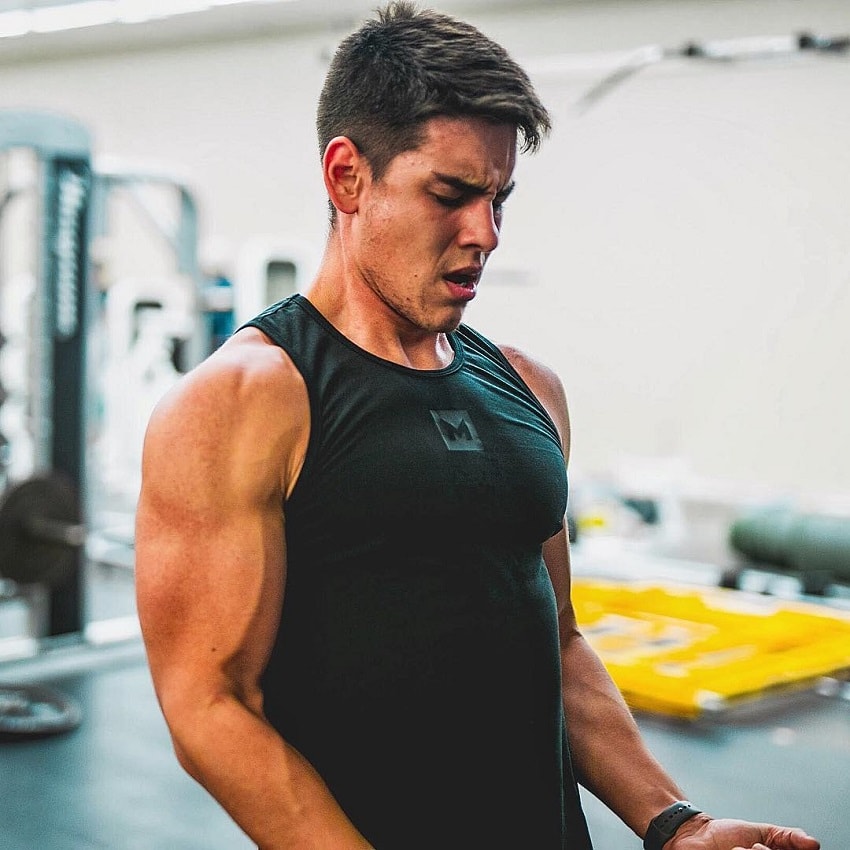 Gabriel Arones lifting heavy biceps curls in the gym