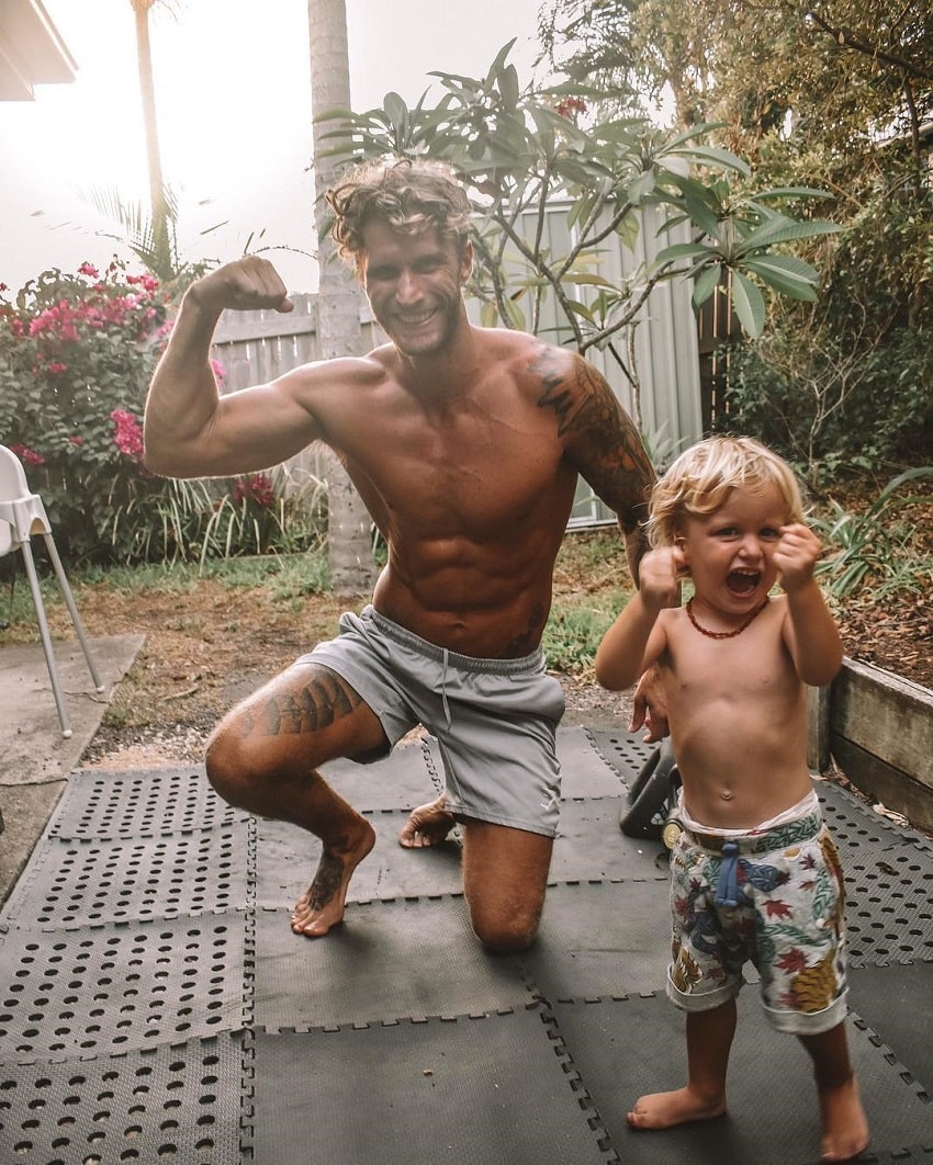 Matt Fox flexing with his son