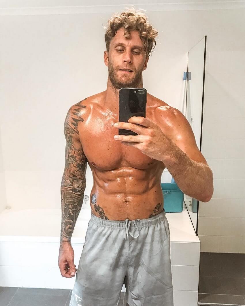 Matt Fox taking a shirtless selfie of his ripped physique