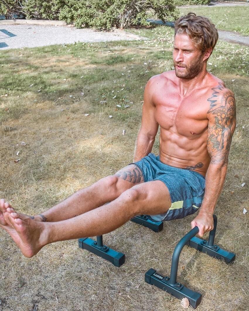 Matt Fox doing calisthencs shirtless outdoors