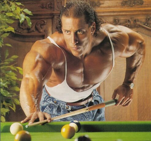 Mike Quinn playing pool in a white tank top looking huge