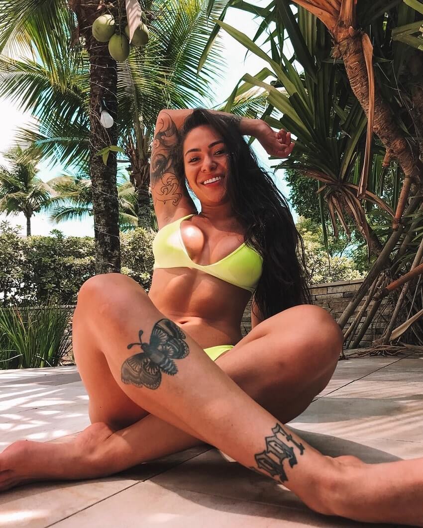 Paola Matoso posing in a yellow swimsuit looking fit and healthy