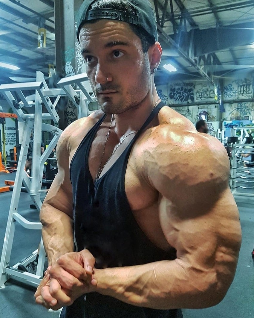 Rafael Rey flexing his vascular and builging shoulders in the gym