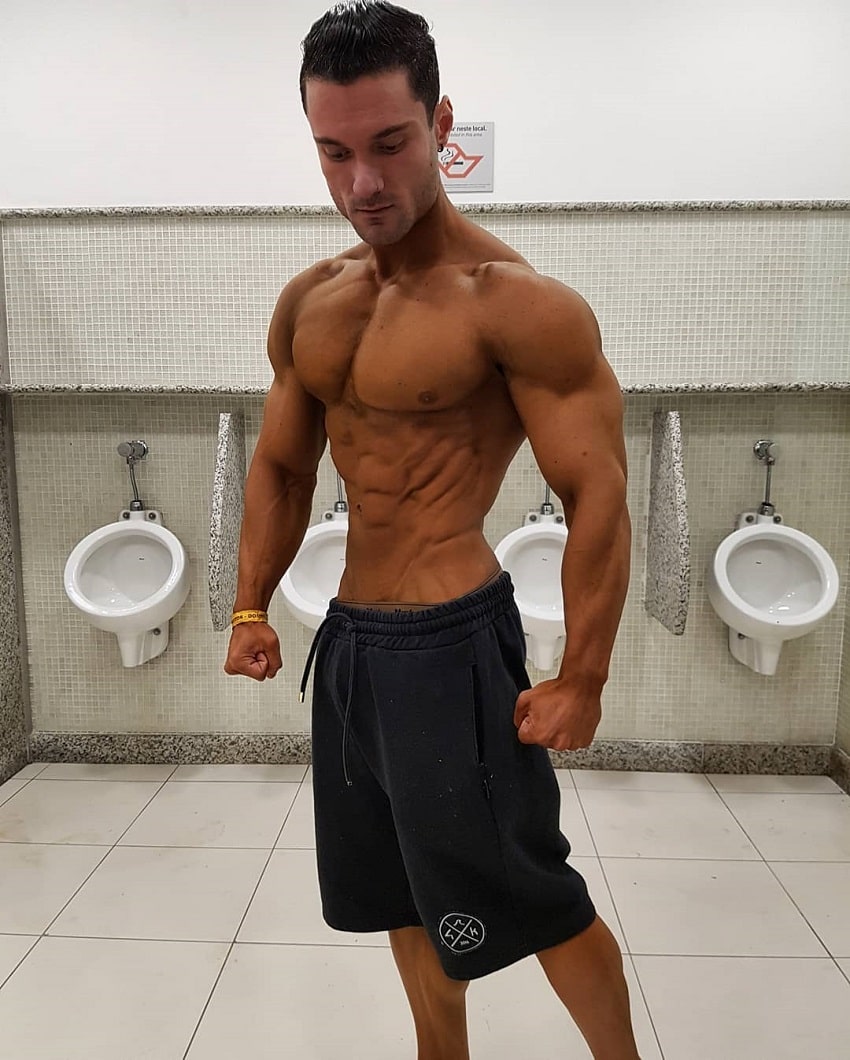 Rafael Rey standing shirtless in the bathroom looking tanned up and ripped