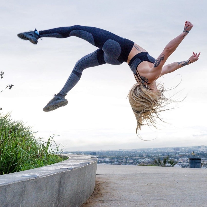 Skylar Stegner doing acrobatics outdoors on concrete near the sea