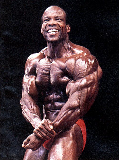 Albert Beckles flexing his ripped muscles on a bodybuilding stage