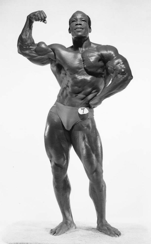 Albert Beckles flexing his biceps shirtless bodybuilding