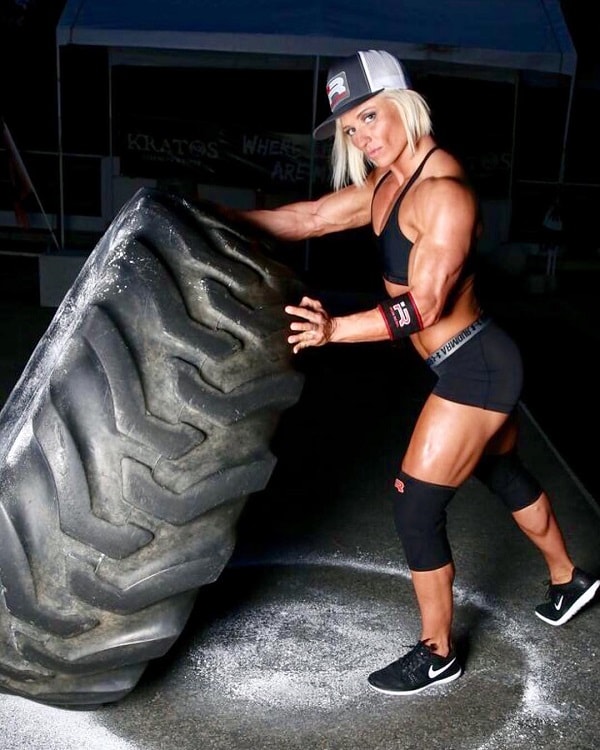 Brooke Walker lifting a heavy tire in a fitness photo shoot