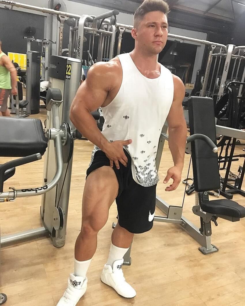 Caique Meirelles flexing his legs in teh gym looking huge
