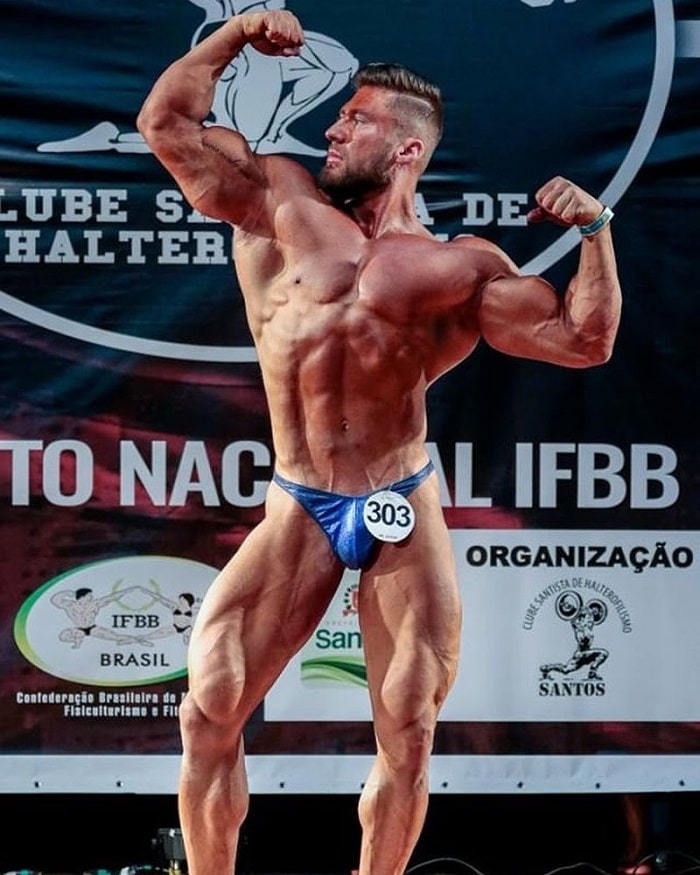 Caique Meirelles doing a frank zane and Zyzz pose on the bodybuilding stage