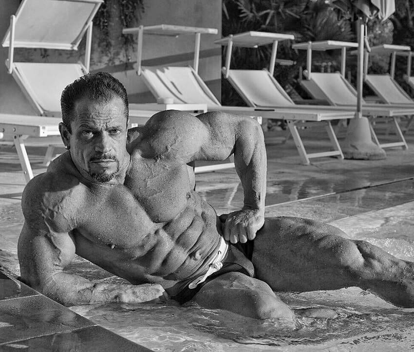 Fernando Sardinha posing shirtless by the pool, looking ripped