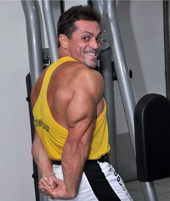 Fernando Sardinha flexing his triceps and smiling