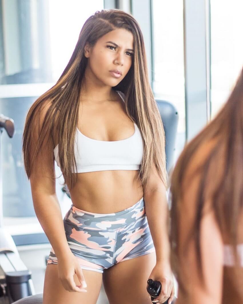 Johanna Sophia posing in front of a mirror in the gym