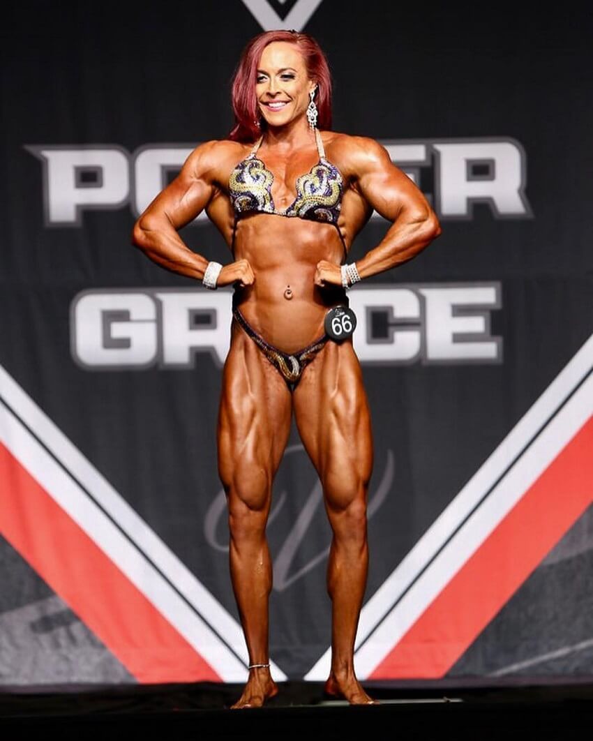 Katie Lee posing on the Women's Physique stage