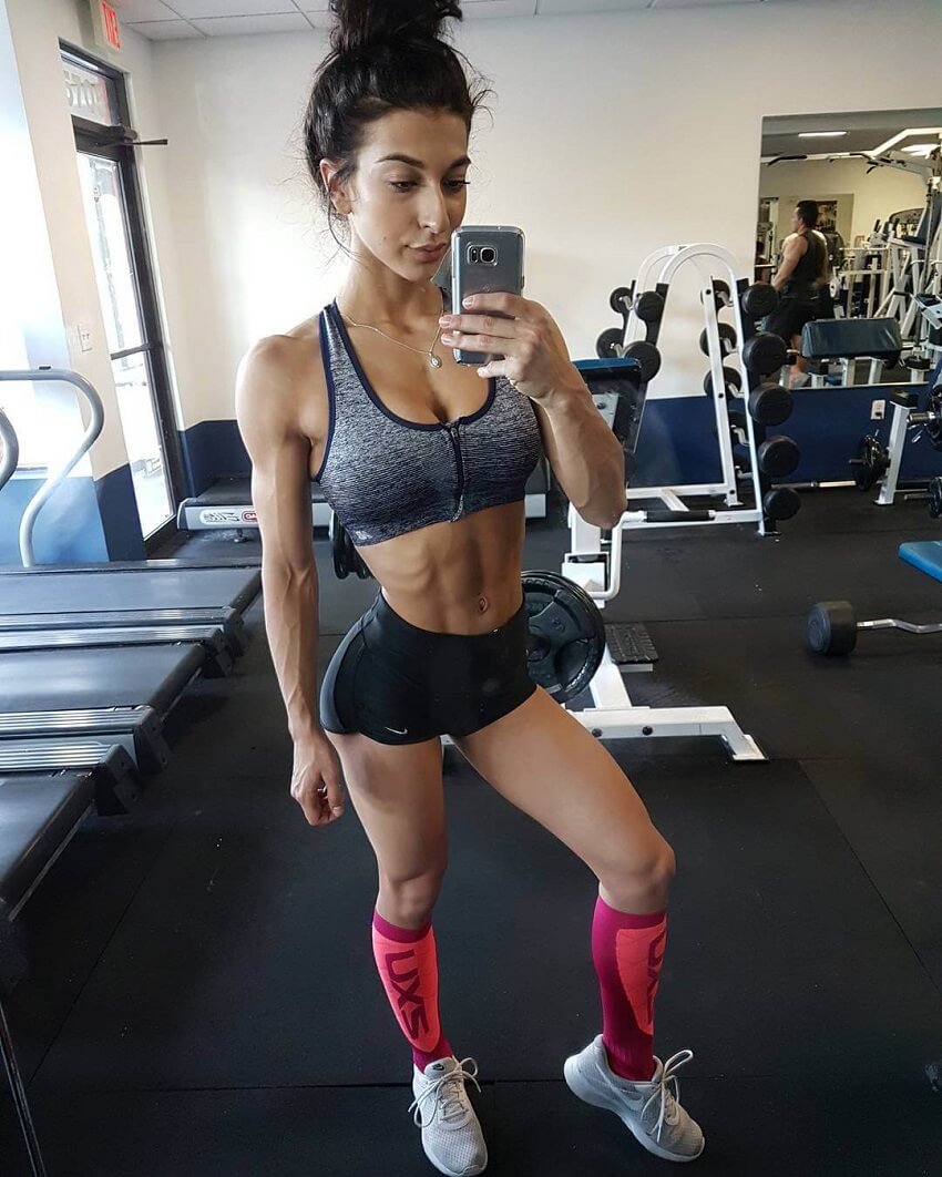 Lauralie Chapados taking a picture of her toned figure in a cardio room