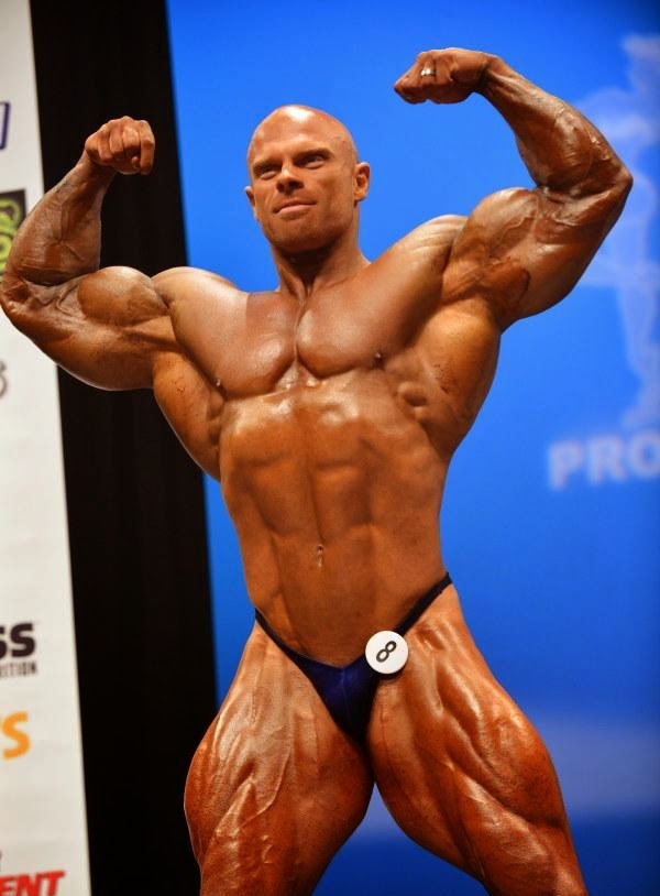 Marius Dohne doing a front double biceps pose on the bodybuilding stage