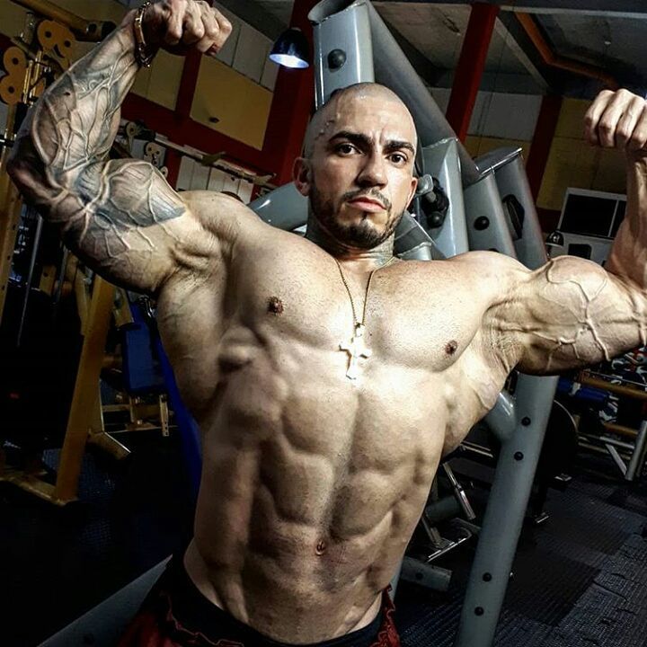 Matheus Donaire doing a shirtless front double biceps flex