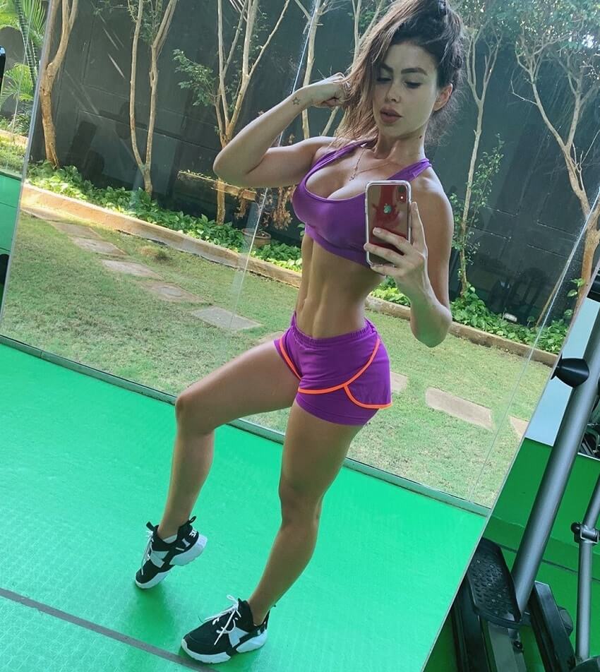 Paola Canas taking a selfie of her fit and lean figure during a workout
