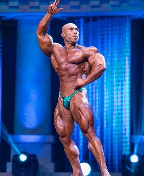 Samir Troudi performing a pose in a bodybuilding competition