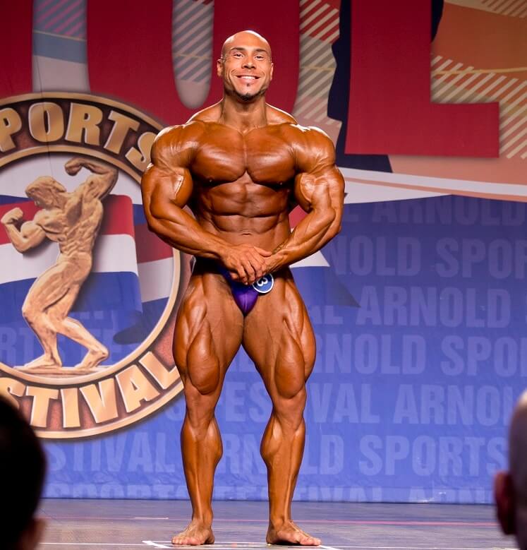 Samir Troudi flexing in his most muscular pose on the bodybuilding stage