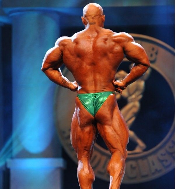 Samir Troudi performing a rear lat spread on a bodybuilding stage