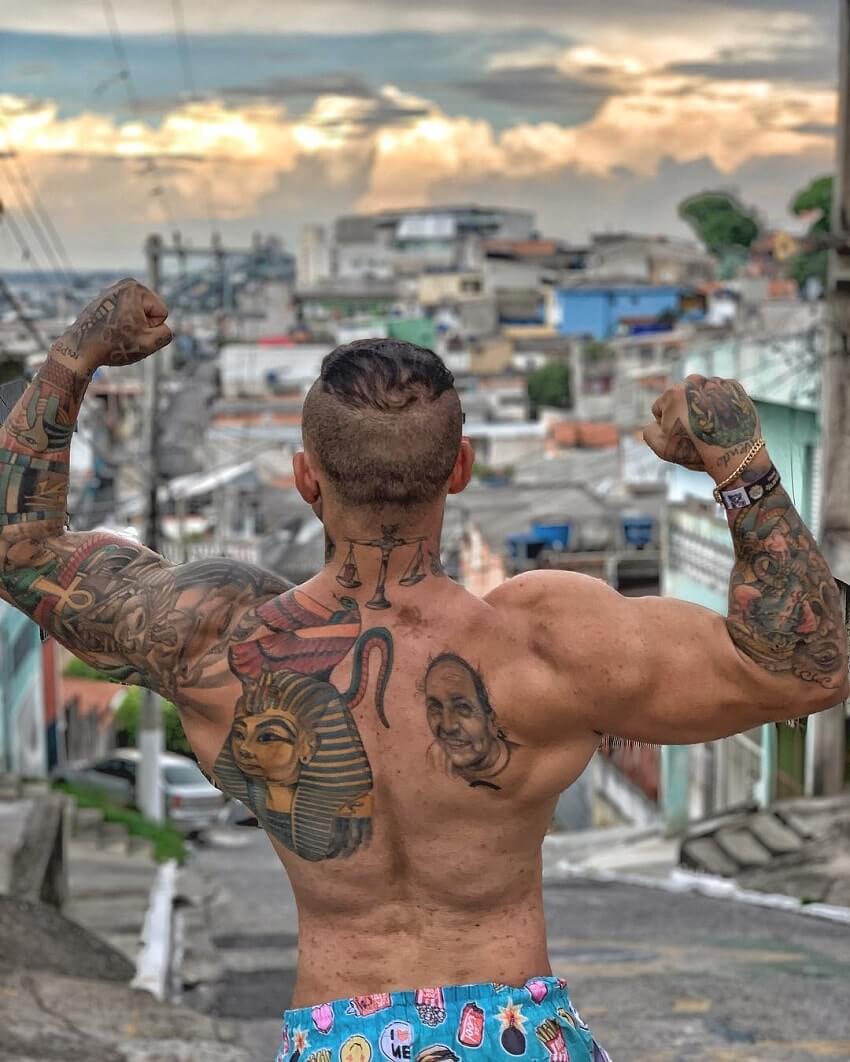 Tiago Toguro performing a bodybuilding pose shirtless on the street