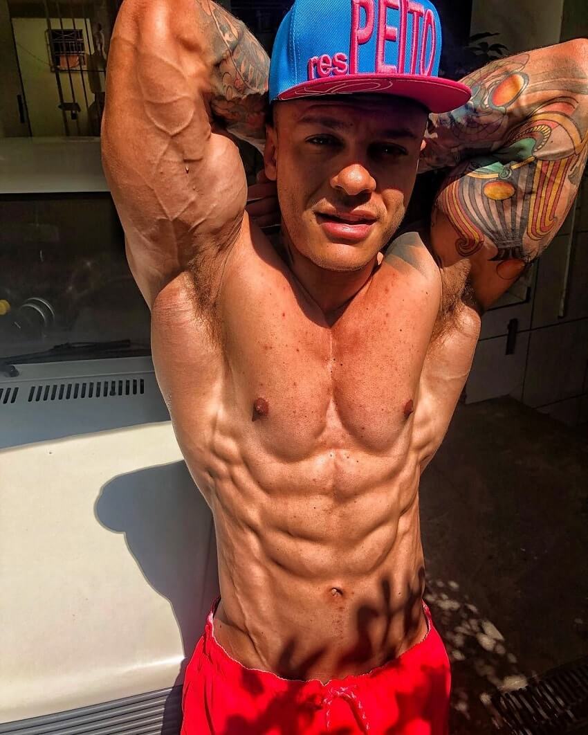 Tiago Toguro flexing his ripped and muscular abs in the photo