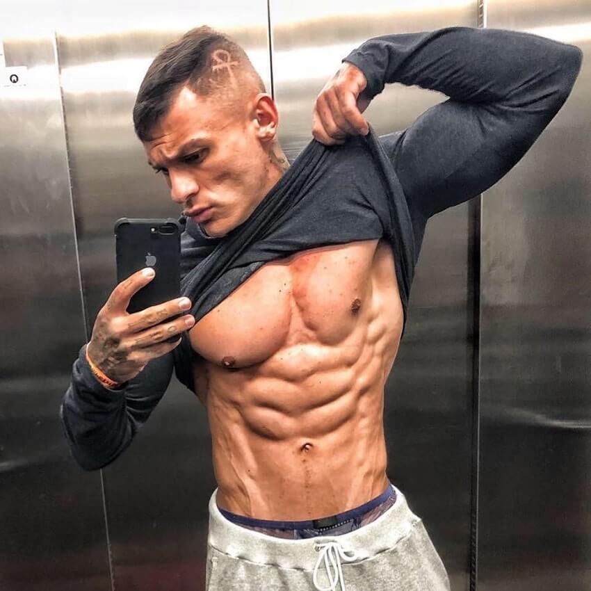 Tiago Toguro flexing his bulging abs in an elevator selfie