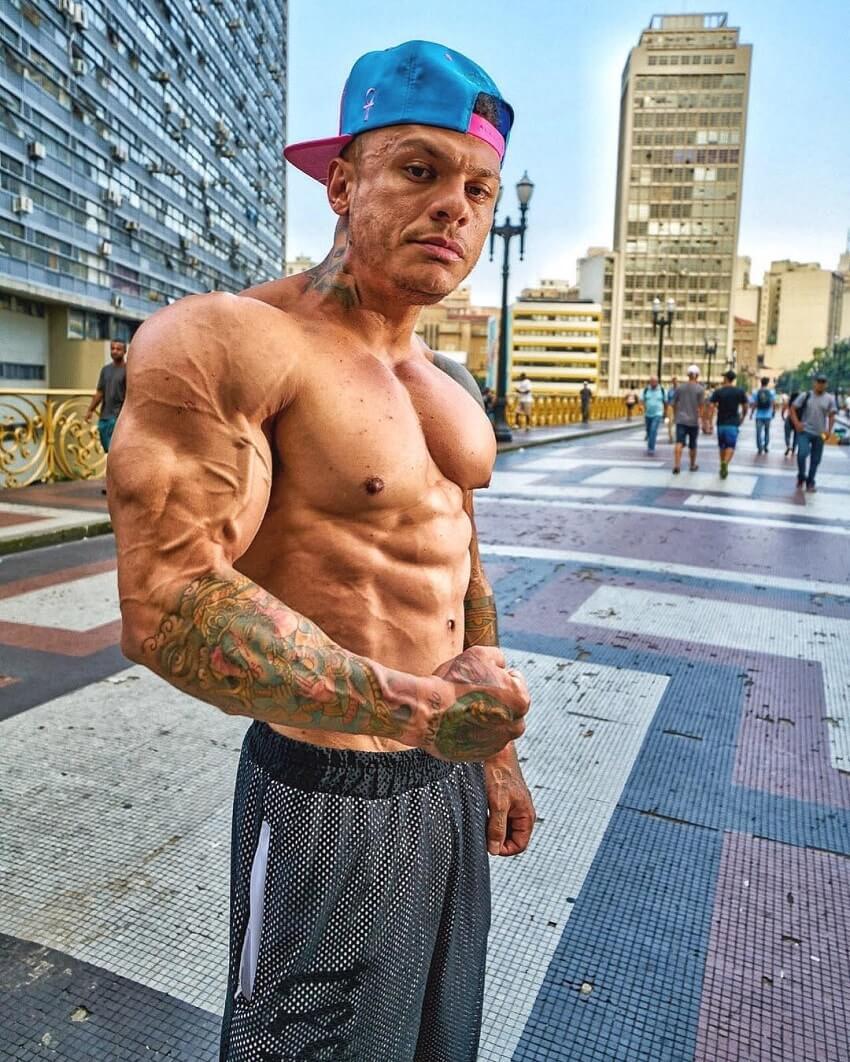 Tiago Toguro posing shirtless on the city street